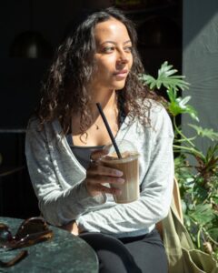 Woman sitting outside wearing a wrap-a-round top in grey melange color. Kvinna sitter utomhus klädd i en gråmelerad omlott top