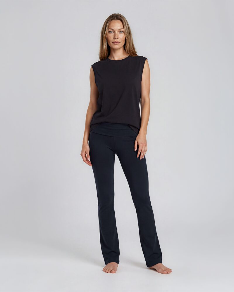 Woman wearing flared tights and a tank top - full front. Kvinna i svart tank top och svarta flared yoga tights.