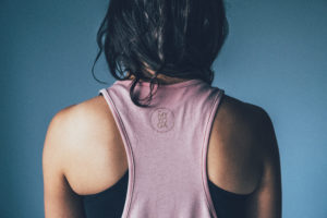 Pink sports tank top with logo in gold at the back.