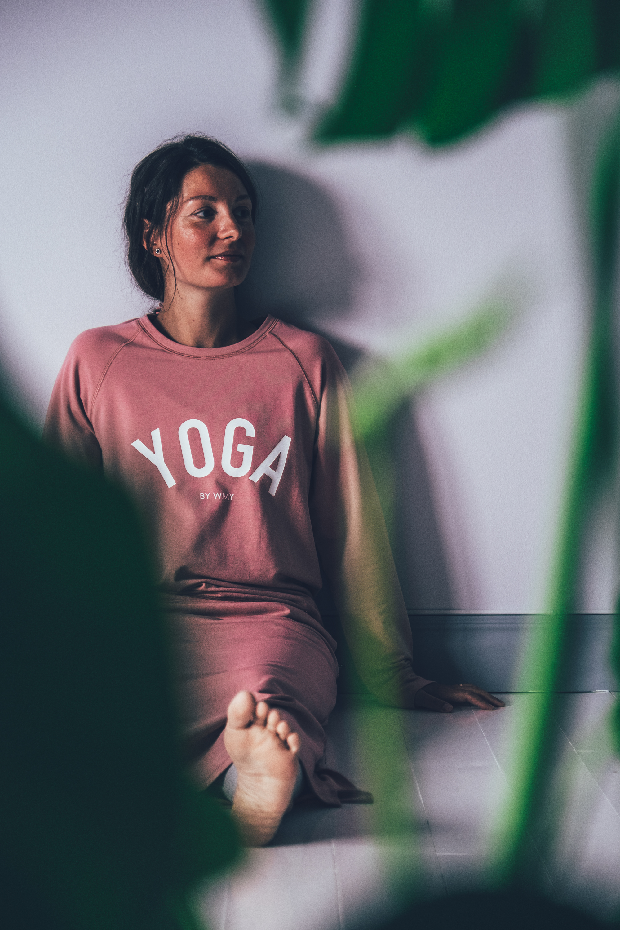 Model wearing a pink yogasweater with the letters YOGA in white.