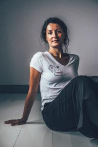 Model wearing a white V-neck t-shirt with yoga print on the chest.
