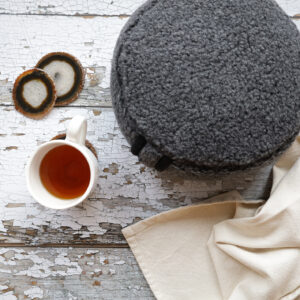 Merino meditationspuff, en filt och en kopp te.