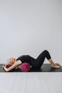Yogi öppnar upp bröstryggen liggandes på Wearmyyoga linne bolster.