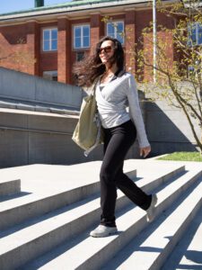 Woman walking outside wearing a wrap-a-round top in grey melange color. Kvinna går utomhus klädd i en gråmelerad omlott top.
